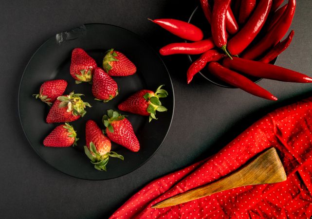 Cloth and branches near peppers and strawberries