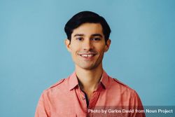 Portrait of smiling Hispanic male on blue background bx1Ka0