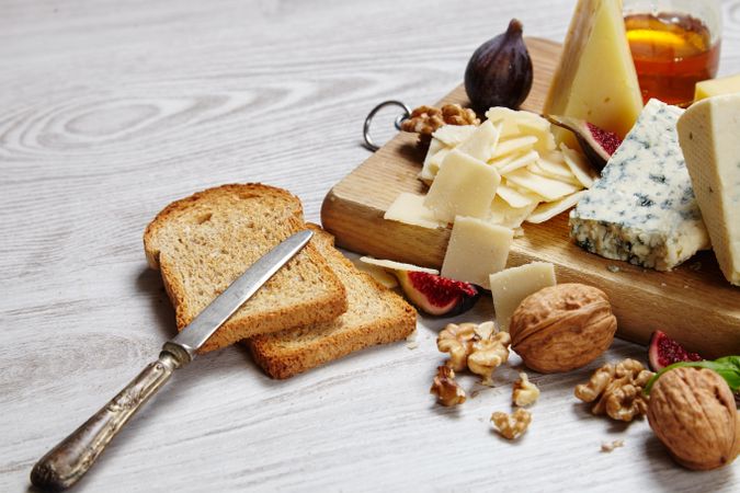 Cheese plate on wooden board with toast