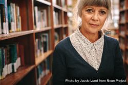 Portrait of a mature woman standing in a library 4A32Q0