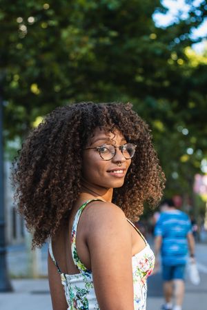 Glad Black woman looking at camera in park