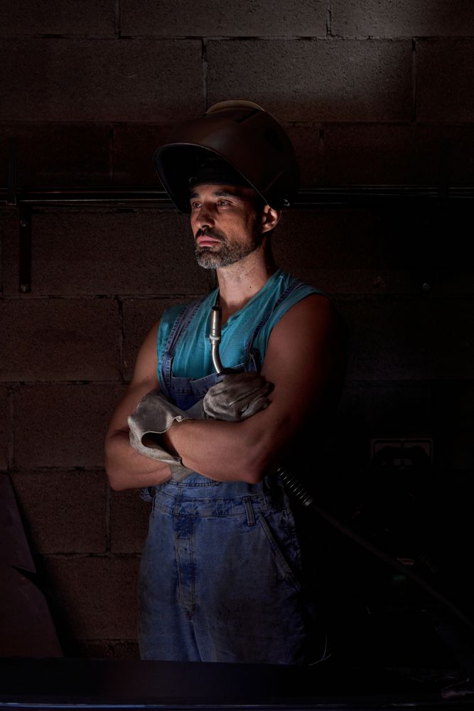 Confident man in welding helmet with arms crossed