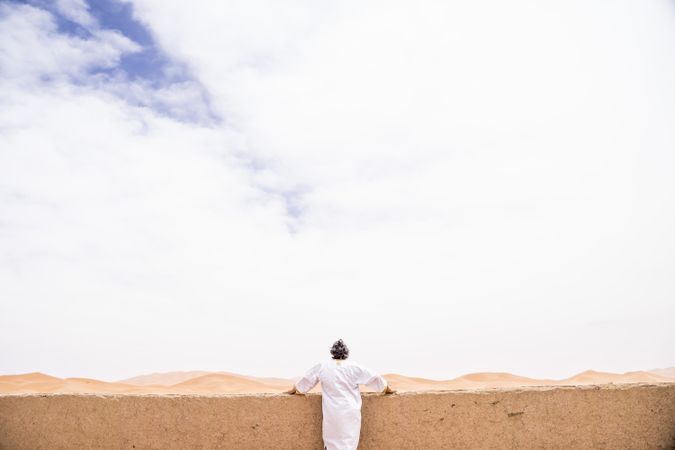 Anonymous man on terrace against desert landscape