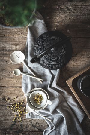 Round teapot and spoons with bowl on linen cloth