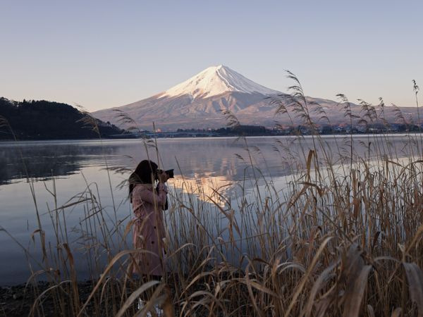 Side view of photographer shooting with her camera near Mount Fuji in Japan
