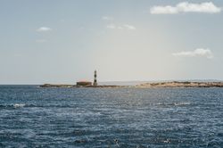 Lighthouse tower in a small rocky island