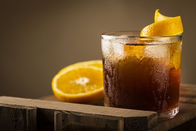 Negroni cocktail with orange, on wooden background.