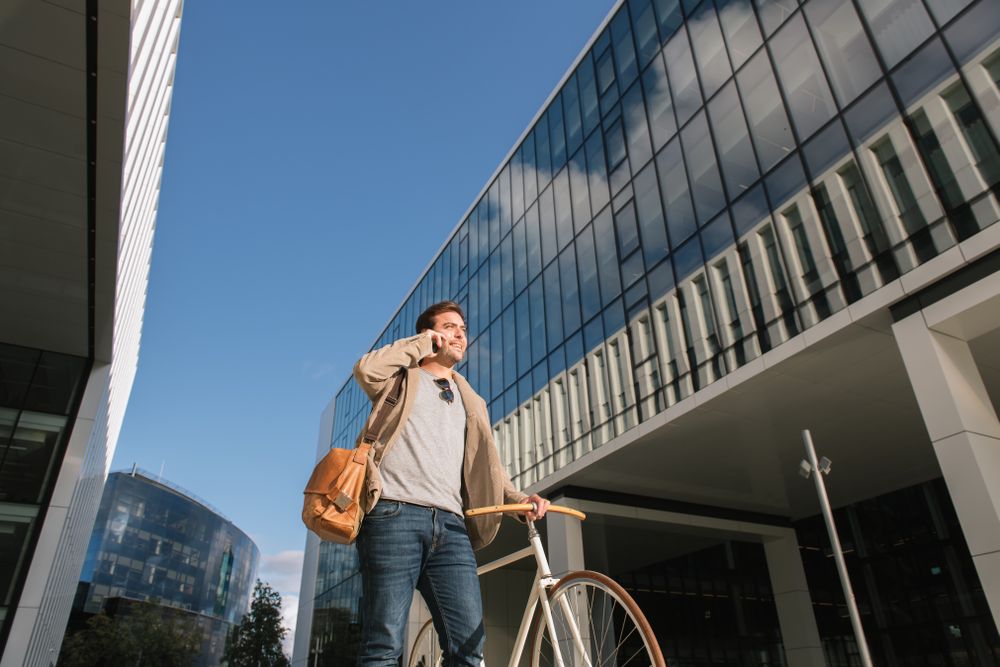Man phoning while standing against modern building in downtown
