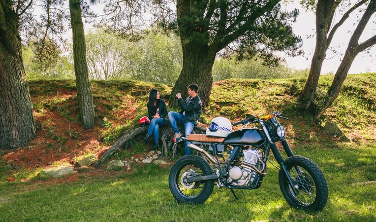 Couple resting from a motorcycle trip taking picture