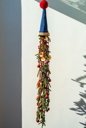 Christmas festive composition with pine, baubles and dried fruit slices topped with hat