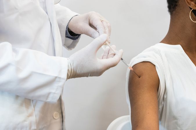 Doctor making injection for Black woman patient