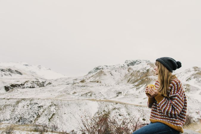 Young woman with cup between mountains