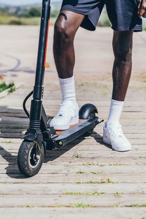 Black man riding on electric scooter in park