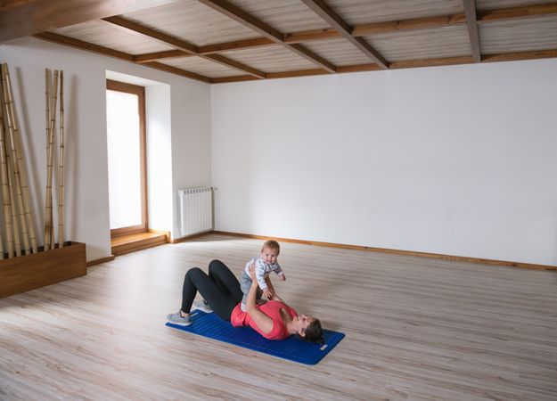 Mother exercising with baby in gym