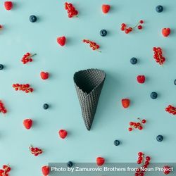 Dark waffle cone on blue background with berries 5RdV1b