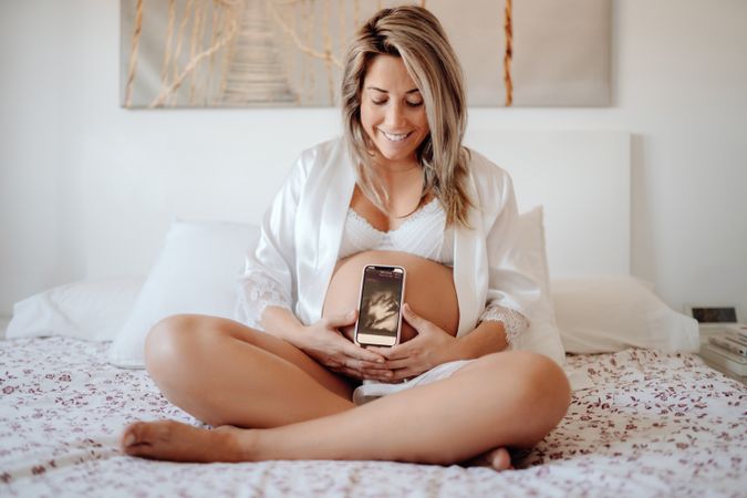 Faceless pregnant woman showing picture from ultrasound scan