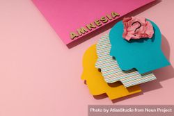 Colorful head shaped heads on pink background with the word “Amnesia” with copy space 0Krl1b