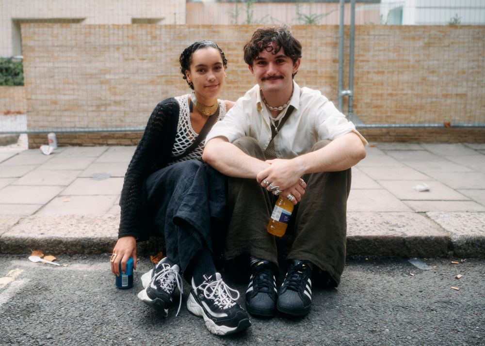 London, England, United Kingdom - August 28, 2022: Couple sitting on curb in London