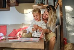 Mother and son sitting on couch and looking at notepad
