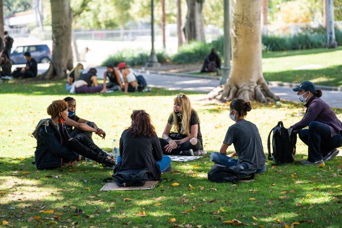 Los Angeles, CA, USA — June 16th, 2020: group of people sitting on grass talking at rally