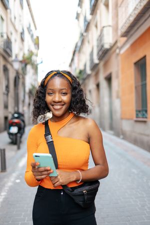 Portrait of a young Black woman using smartphone in the street