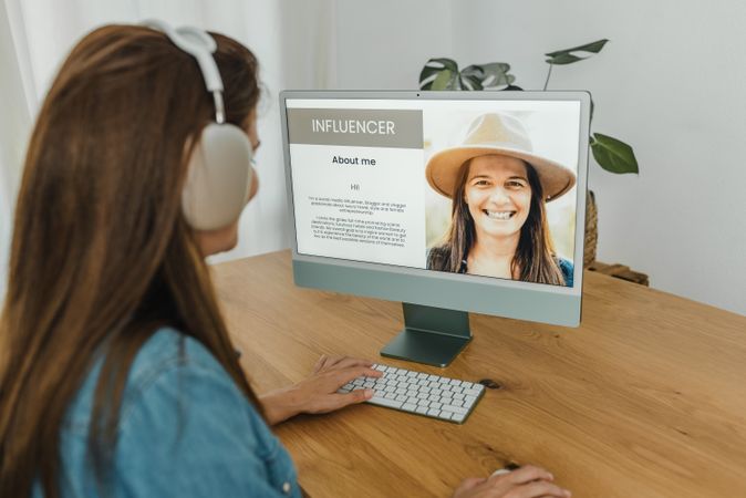 Female influencer using computer and browsing blog
