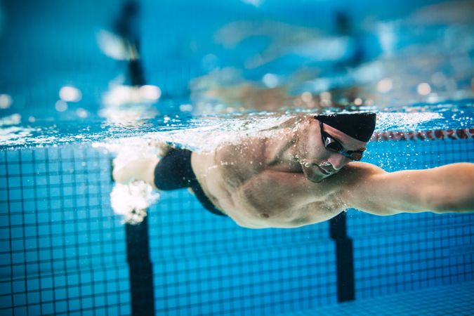 Male swimmer practicing swim speed in lap pool