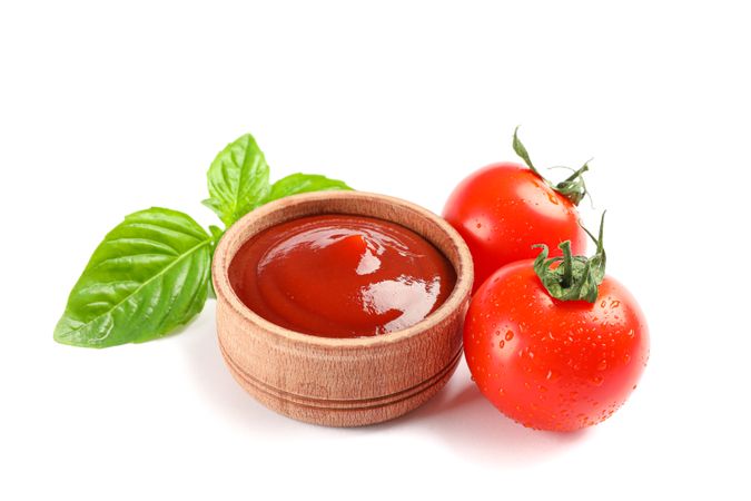 Fresh cherry tomatoes with basil and sauce isolated on blank background. Ripe vegetables