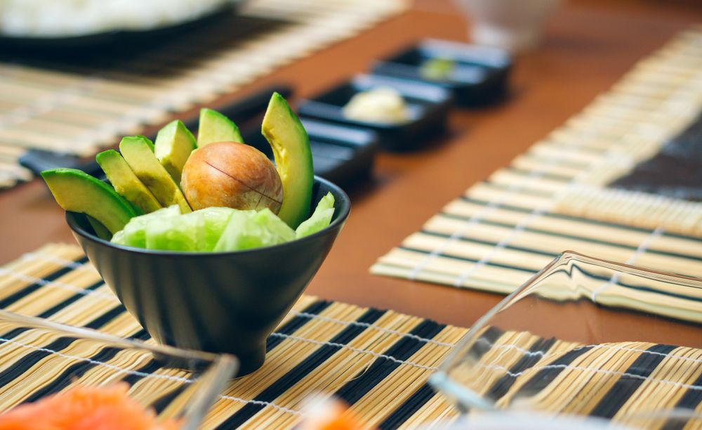 Detail of bowl of avocado cut along with other ingredients ready to prepare sushi
