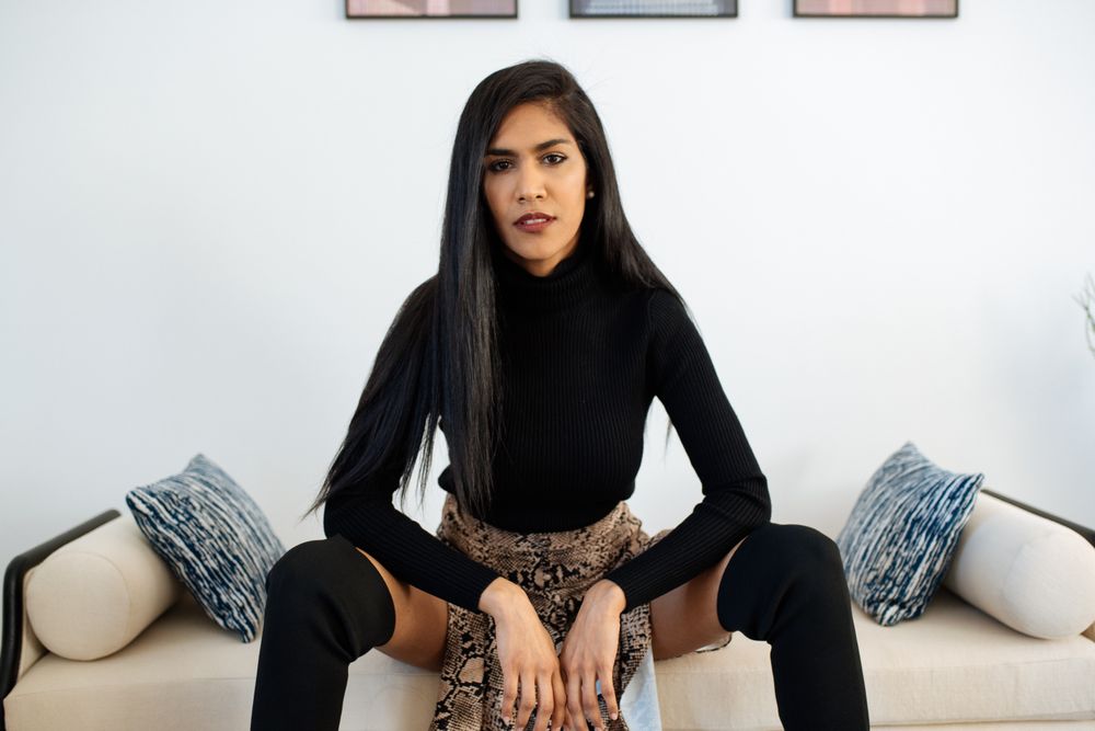 Stylist beautiful young Black woman sitting in a couch