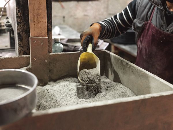 Unrecognizable worker scooping dry material