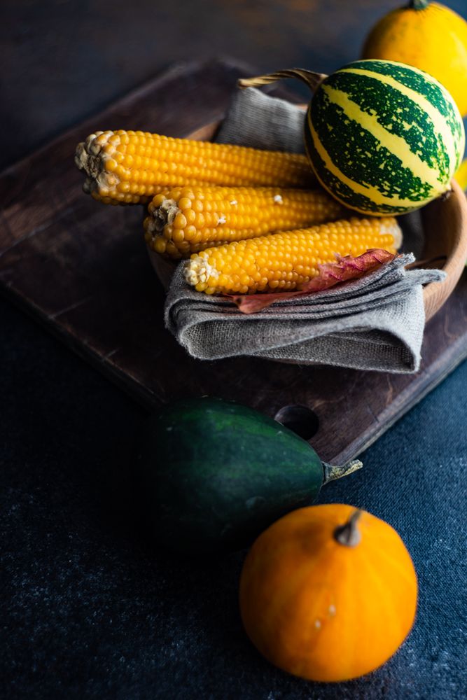 Corn and mini squashed in rustic table setting