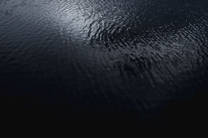 Dark ribbed water surface reflecting the sky