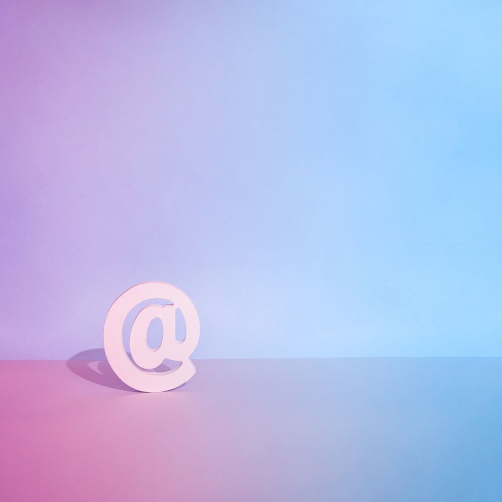 Internet “at” symbol on a gradient pink to blue background
