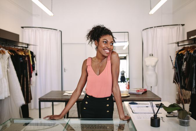Black fashion designer smiling in her clothing shop