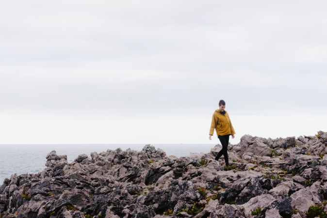 Traveler in solitude walking on rocky shore