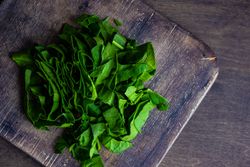 Fresh cut spinach on wooden board