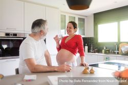 Happy white couple, pregnant woman with husband in kitchen 5wzgL0