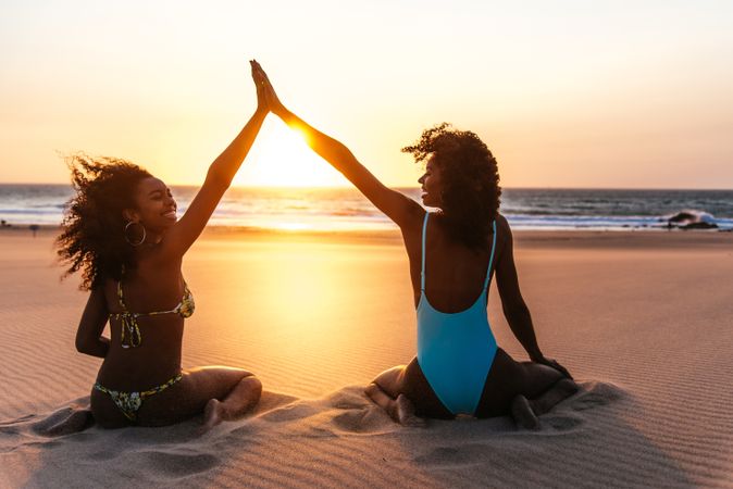 Content Black woman on tropical beach at sunset