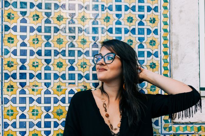 female holding hair against tiled wall