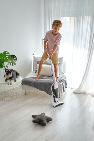 Boy tidying floor from chair