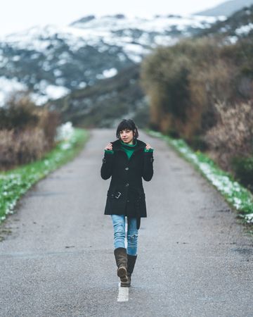 Young woman walking on empty road