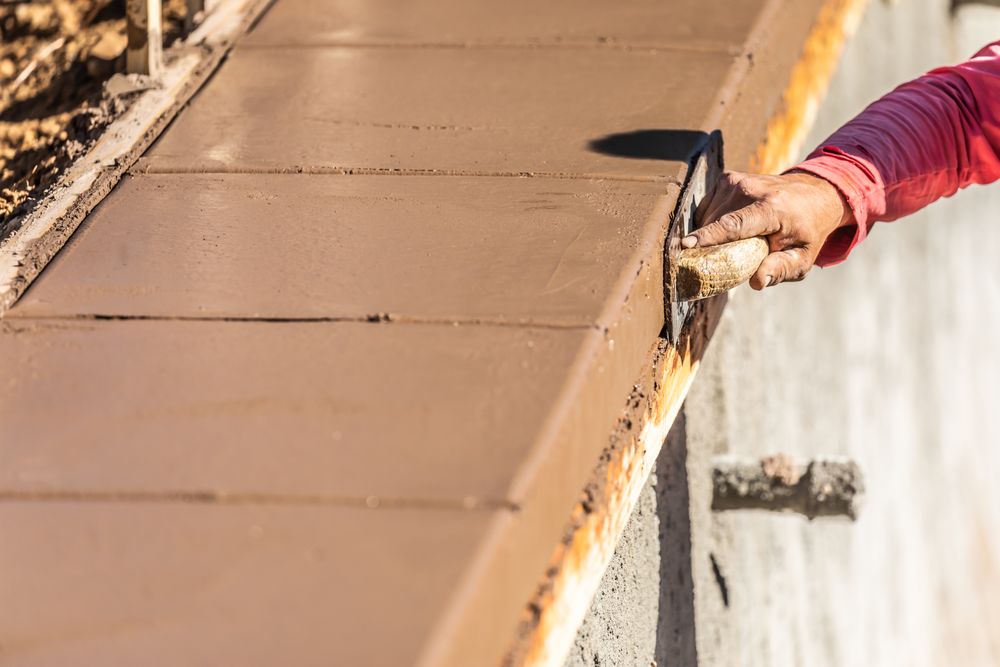 Construction Worker Using Stainless Steel Edger On Wet Cement Forming Coping Around New Pool