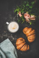 Coffee with croissants and pink roses