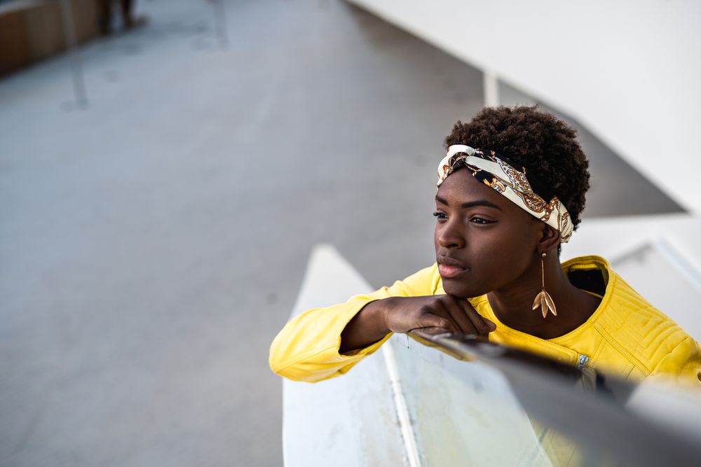 Satisfied female having rest on stairs in city