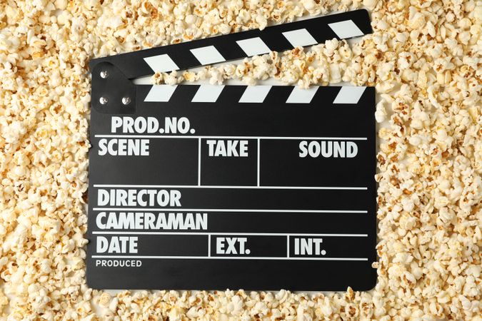 Clapperboard and many popcorn, top view