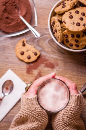 Female hands with hot drink and chocolate cookies
