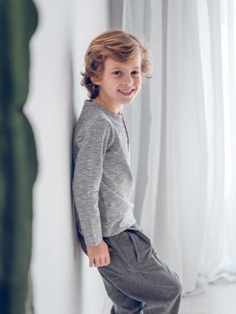Cheerful boy standing near wall