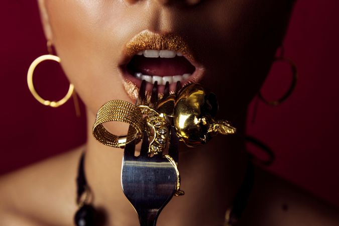 Woman eating golden jewelry