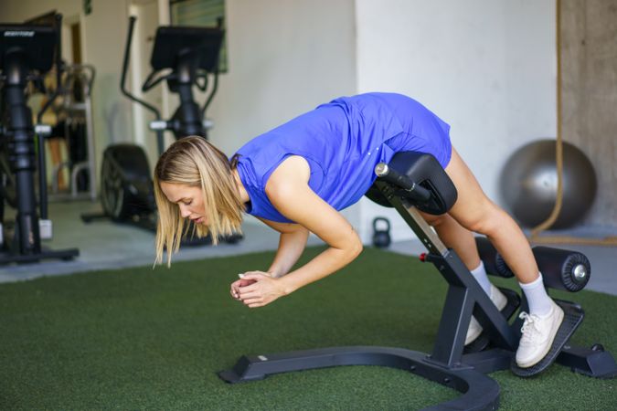 Young fitness woman doing incline sit-up exercises